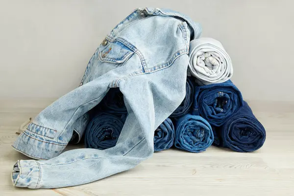 A pile of jeans on a gray background.