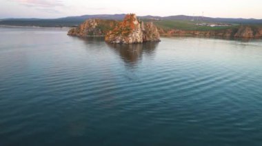 Shamanka Kayası, Baykal Gölü bir yaz akşamı. Sap tahtalarındaki turistler körfezde yüzüyor. 