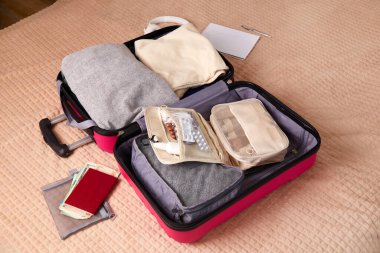 Seyahatten önce kişisel eşyaları pembe bir bavula koymak. Seyahat kavramı.