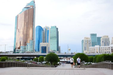 ASTANA, KAZAKHSTAN - 17 Temmuz 2023 Astana 'nın merkezinde yuvarlak bir meydan, Ulaştırma Bakanlığı' nın bulunduğu yüksek gökdelen, idari kompleks ulaşım kulesi manzarası 