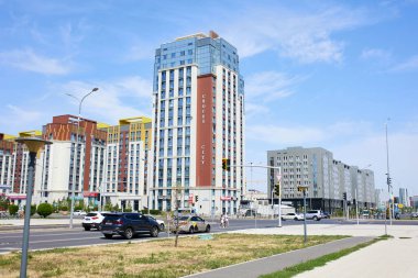 ASTANA, KAZAKHSTAN - 17 Temmuz 2023 Uly Dala Bulvarı, Crocus City yerleşim yeri. Şehir merkezinde güneşli bir günde yüksek binalar ve araçlarla modern şehir manzarası