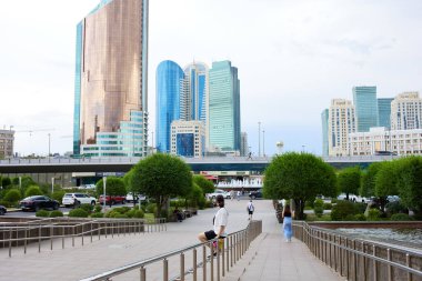 ASTANA, KAZAKHSTAN - 17 Temmuz 2023 Astana 'nın merkezinde yuvarlak bir meydan, Ulaştırma Bakanlığı' nın bulunduğu yüksek gökdelen, idari kompleks ulaşım kulesi manzarası 