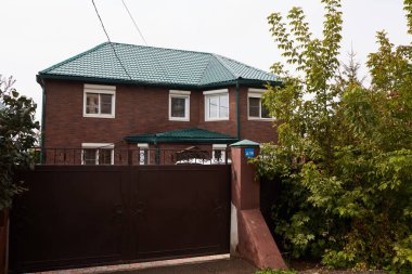 Bir banliyö bölgesinde modern tuğla ev ve geniş bir bahçe..