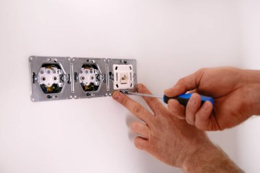 Modern bir iç mekanda tornavidayla elektrik prizi kuruyorum.. 