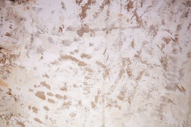 Eski alçılı duvar sökülmüş, onarım için hazırlanıyor. Sıcak gün ışığında, duvar aşınma izleri gösteriyor, boya ve doku soyuluyor.. 