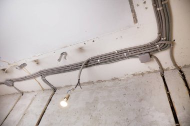 Tavana elektrik kabloları döşenmiş. Tamir odasındaki kablo borularındaki elektrik kabloları....