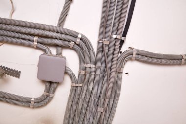 Koruyucu kablo tüpündeki elektrik kabloları ve bağlantı kutusu düzgünce tavana yerleştirilmiş. Tamir odasına elektrik tesisatı kurulumu.