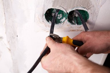 Elektrikçi güpegündüz bir yerleşim yerinde elektrik tesisatı tamir ediyor.. 