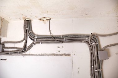 Tavana elektrik kabloları döşenmiş. Tamir odasındaki kablo borularındaki elektrik kabloları....