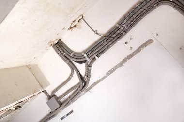 Tavana elektrik kabloları döşenmiş. Tamir odasındaki kablo borularındaki elektrik kabloları....