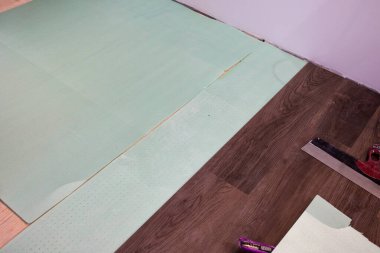 Alttaki tabana kaplama tahtaları ya da parke döşemek. Ev yenileme konsepti