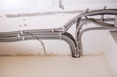Tavana elektrik kabloları döşenmiş. Tamir odasındaki kablo borularındaki elektrik kabloları....