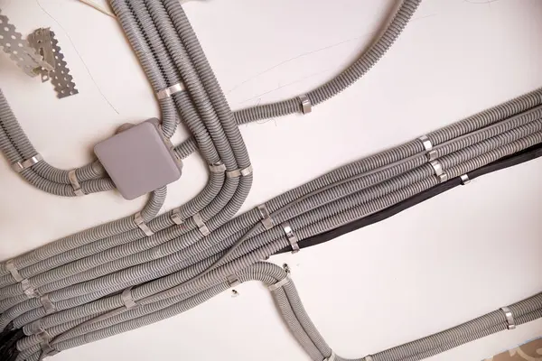 Koruyucu kablo tüpündeki elektrik kabloları ve bağlantı kutusu düzgünce tavana yerleştirilmiş. Tamir odasına elektrik tesisatı kurulumu.