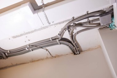 Tavana elektrik kabloları döşenmiş. Tamir odasındaki kablo borularındaki elektrik kabloları....