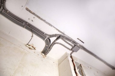 Tavana elektrik kabloları döşenmiş. Tamir odasındaki kablo borularındaki elektrik kabloları....