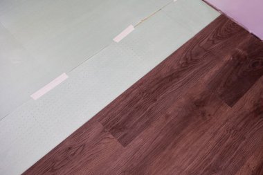 Alttaki tabana kaplama tahtaları ya da parke döşemek. Ev yenileme konsepti