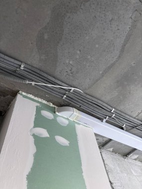 Tavana elektrik kabloları döşenmiş. Tamir odasındaki kablo borularındaki elektrik kabloları....