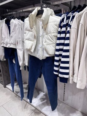 İlkbahar ya da sonbahar kadın kıyafetleri koleksiyonu. Modern perakende mağazasının iç mekanında günlük kıyafet ve ayakkabılar sergileniyor. Tarafsız tonlarda, şık ve düzenli bir düzende.