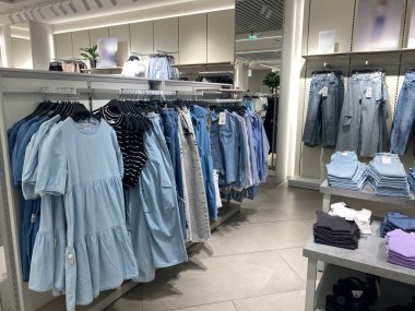 Modern bir butikte kotlar ve günlük giysiler sergileniyor..