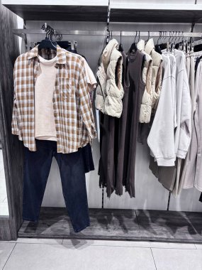Moda kadın giyim koleksiyonu. Modern perakende mağazasının iç mimarisi günlük kıyafetleri gün içinde nötr tonlarda düzenli ve şık bir şekilde sergiliyor.
