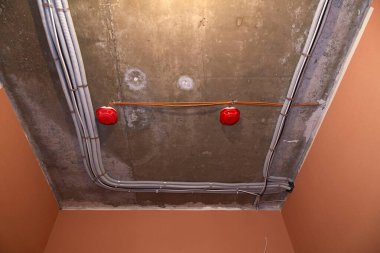 İnşaat çalışmalarının devam ettiği binanın tavanına elektrik kabloları ve kırmızı yangın dedektörleri yerleştirildi. Duvarlar kırmızı ve turuncu renklerle boyanmıştır.. 