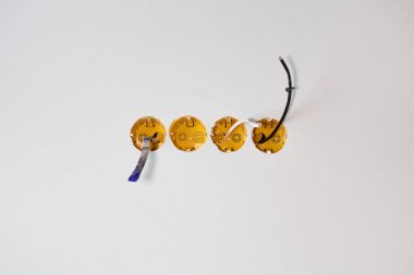 Duvara örülmüş dört tane elektrik kutusu var. İçlerinde kablolar var. Soketleri kurmak için çalışmalar sürüyor.