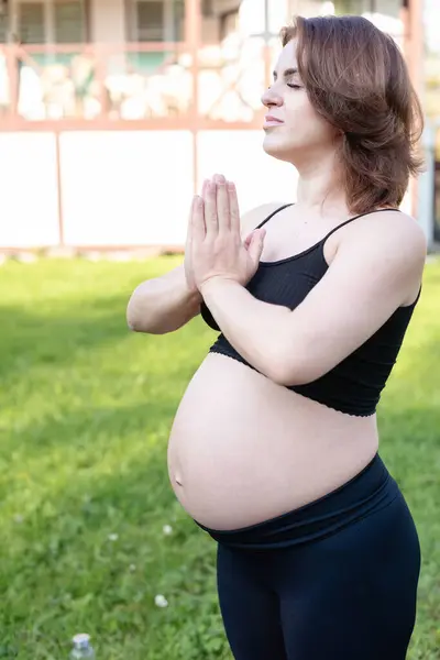 妊娠中の女性は ヨガ屋外で呼吸して落ち着き 草の上のストレッチエクササイズを行います セルフケア マタニティコンセプト ヘルスケア 趣味を楽しむ — ストック写真
