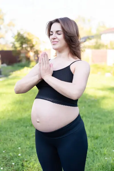 怀孕妇女呼吸平静 在室外使用瑜伽 在草地上做伸展运动 自我照顾 母性概念 享受母性 医疗保健 业余爱好 — 图库照片