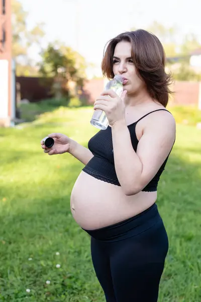 Těhotná Žena Sportovním Oblečení Pije Láhev Vody Józe Venku Dává — Stock fotografie