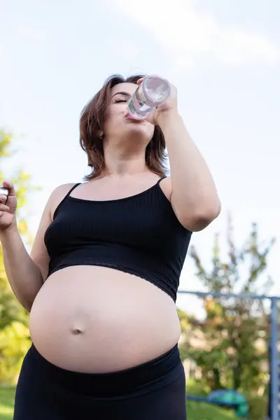 Gravid Kvinde Sportstøj Drikker Flaske Vand Efter Have Gjort Yoga - Stock-foto