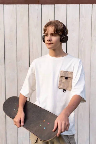 Adolescente Fones Ouvido Segurando Skate Livre Fundo Branco Madeira Criança Imagens De Bancos De Imagens Sem Royalties