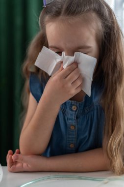 Mavi elbiseli, mendille hapşıran beyaz bir kız..