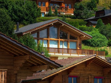 Alp İsviçre Köyü. Rahatlık ve sükunet. Güneşli bir yaz günü. Pencerelerde çiçekler var. Tahta kiremitler.