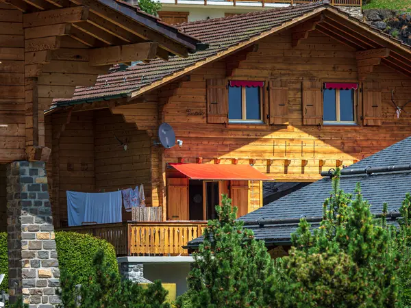 アルパイン スイス村 快適さと静けさについて 晴れた夏の日 窓に咲いている花 ウッド シャレー ストック画像