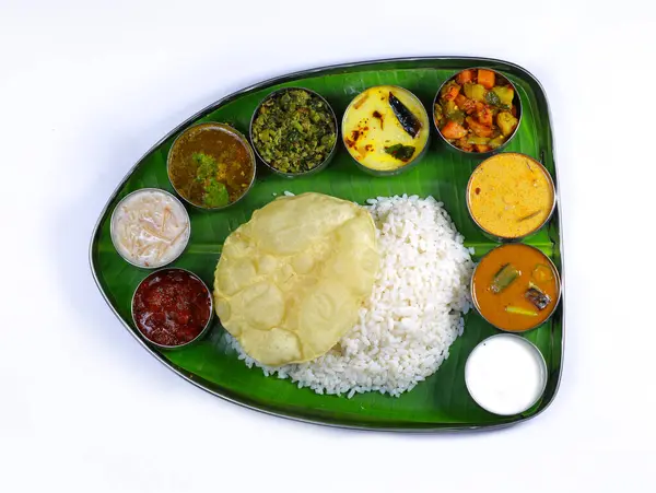 Traditional Indian meal served on a banana leaf with rice, curry, various vegetables, and sauces, evoking a sense of culture, authenticity, and culinary diversity.