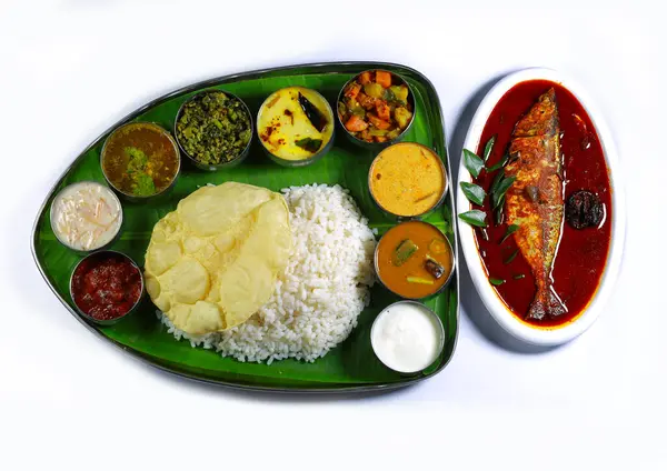 Kerala fish curry meals. Traditional South Indian meal served on a banana leaf with rice, curry, vegetables, papadum, and a side of fish, showcasing vibrant colors and rich culinary culture.