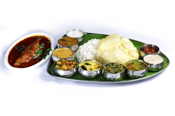 Kerala meals with fish curryTraditional South Indian meal served on a banana leaf with rice, curry, vegetables, papadum, and a side of fish, showcasing vibrant colors and rich culinary culture.