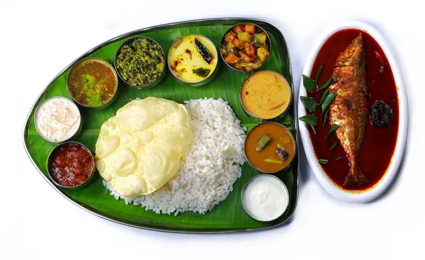 Kerala meals with fish curryTraditional South Indian meal served on a banana leaf with rice, curry, vegetables, papadum, and a side of fish, showcasing vibrant colors and rich culinary culture.