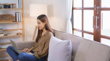 Ev kavramında çalışan kadın serbest yazar, iş verilerini okur ve dizüstü bilgisayarda mali rapor yazar.