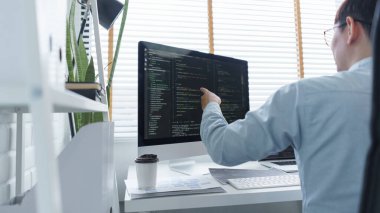 Yazılım geliştirme kavramı, belge ve bilgisayar ekranında veri kodlarını kontrol eden erkek programcı.