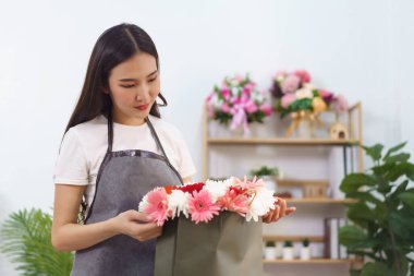 Çiçekçi konsepti, kasımpatı yapan kadın çiçekçi ve Gerbera çiçek buketi..