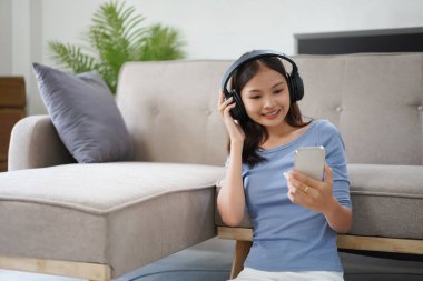 Work from home concept, Business women is relaxation to listening music on smartphone at home.
