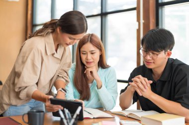 Üniversite eğitimi konsepti, öğrencilere matematik dersi vermek için tablete işaret eden kadın öğretmen.