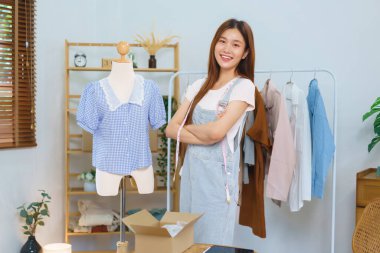 Moda blogcusu konsepti, canlı yayından sonra kolları çapraz duran genç Asyalı kadınlar elbise satıyor.
