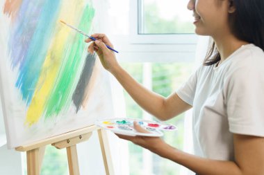 Sanat konsepti, Asyalı kadın sanatçının resim stüdyosunda tuval üzerinde fırça kullanması..
