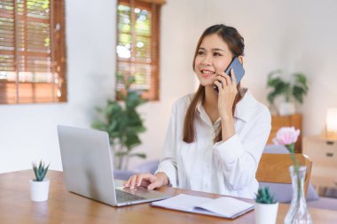 Ev konseptinde çalışan, akıllı telefondan konuşan ve modern ofis bilgisayarında çalışan kadınlar..