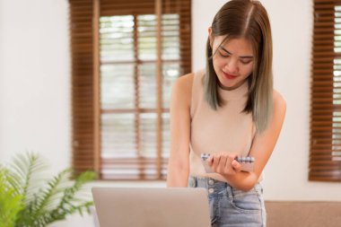 Yaratıcı tasarım konsepti, yeni koleksiyon elbisesi çizen ve dizüstü bilgisayardaki verileri kontrol eden kadın tasarımcı.