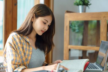 Eğitim ve okur yazarlık kavramı, üniversiteli kız üniversite kütüphanesinde kitap okuyor..