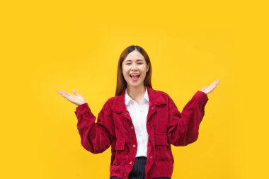 Kadınlar gülümsüyor ve iki elinde bir şey tutarken izole edilmiş sarı arka planda duruyorlar..