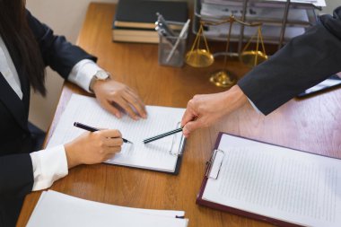 Legal and justice concept, Senior lawyer points on contract to provide law advice to female lawyer.